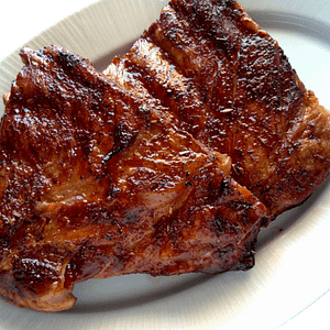Costilla de Cerdo al Horno (Travers de Porc au Four) Des travers de porc méticuleusement marinés, puis lentement rôtis au four jusqu'à obtenir une chair tendre et juteuse sous une peau croustillante. Chaque bouchée est un délice, offrant une explosion de saveurs qui rappelle les repas familiaux chaleureux. Servis traditionnellement avec des légumes rôtis ou une purée, ces travers de porc sont le summum du confort culinaire.